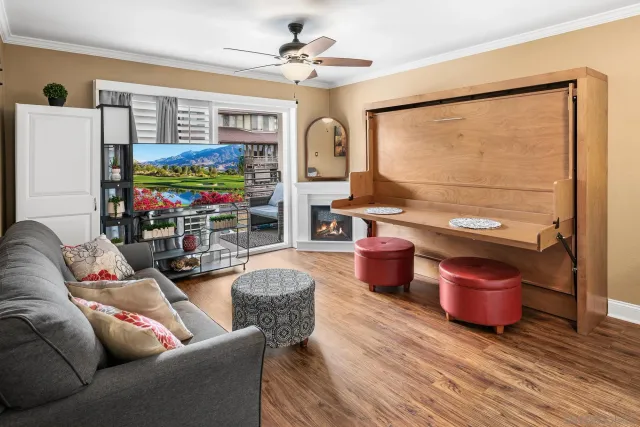 a living room with furniture a flat screen tv and a floor to ceiling window