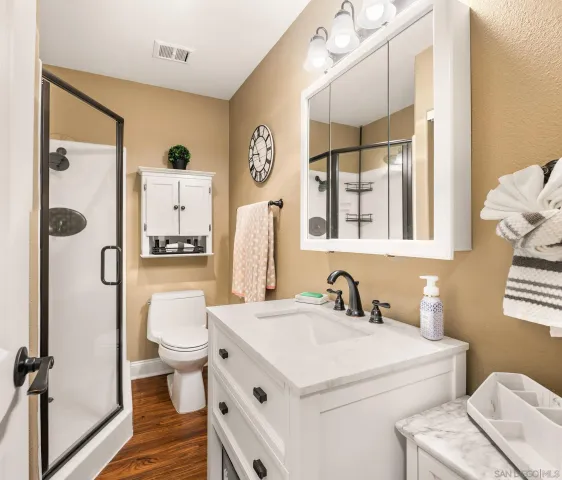 a bathroom with a sink a toilet and shower