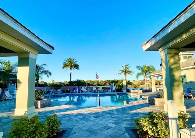 a view of a swimming pool with a lawn chairs under an umbrella
