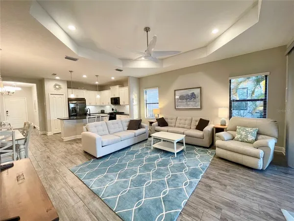 a living room with furniture couches and a view of kitchen