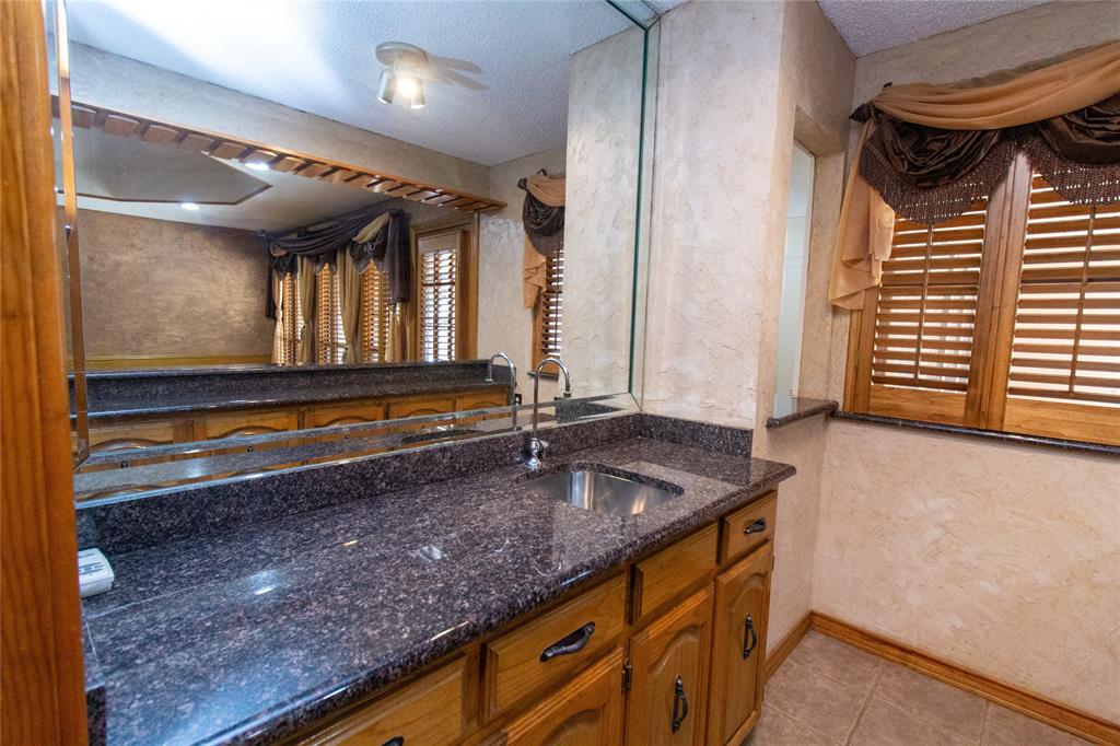 3014 Pecan Ridge Drive Rowlett, TX 75088 - Photo 23 of 29 a kitchen with granite countertop a sink and a window