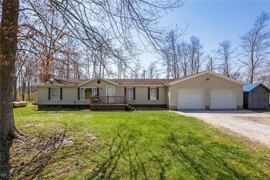 4502 Clover Road Cumberland, OH 43732 - Photo 1 of 38 View of front facade with driveway, an attached garage, a deck, a front lawn, and a storage unit