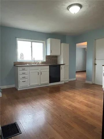 a view of kitchen with granite countertop cabinets and sink