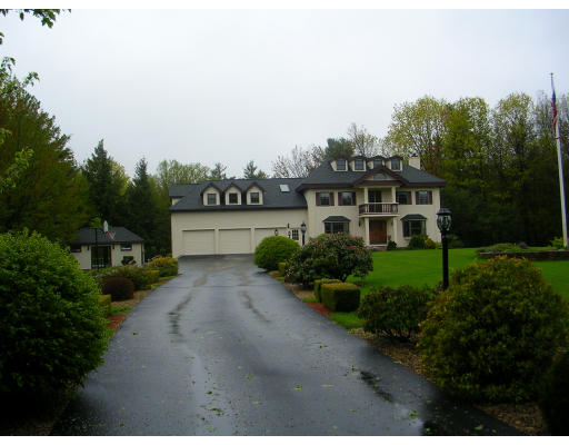 a view of a house with a yard and large trees