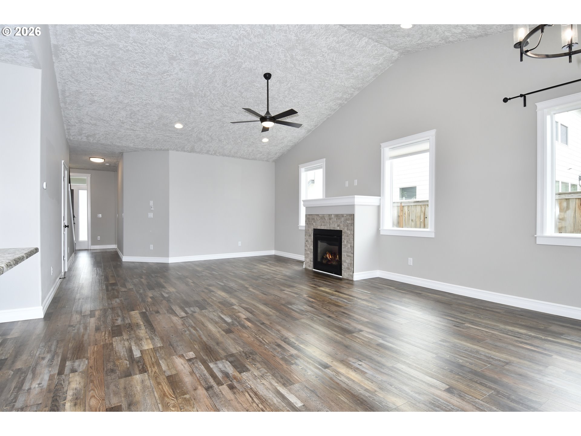 443 Northeast Pine Street Sublimity, OR 97385 - Photo 10 of 26 an empty room with wooden floor fireplace and windows