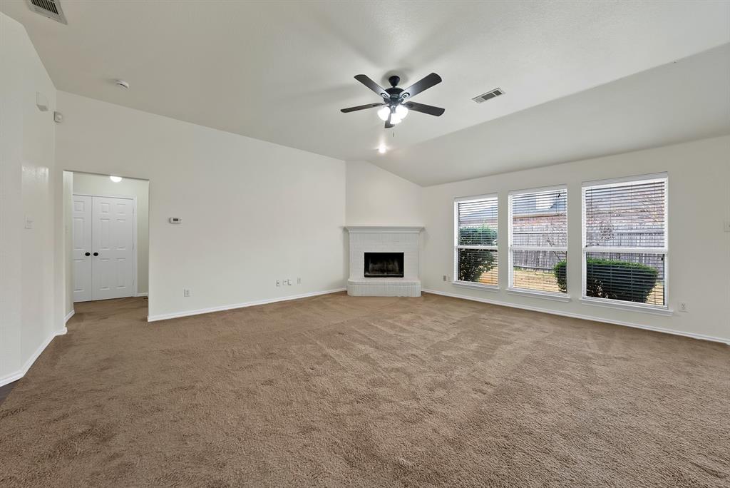 2832 Lone Ranger Trail Little Elm, TX 75068 - Photo 14 of 35 a view of an empty room with a fireplace and a window