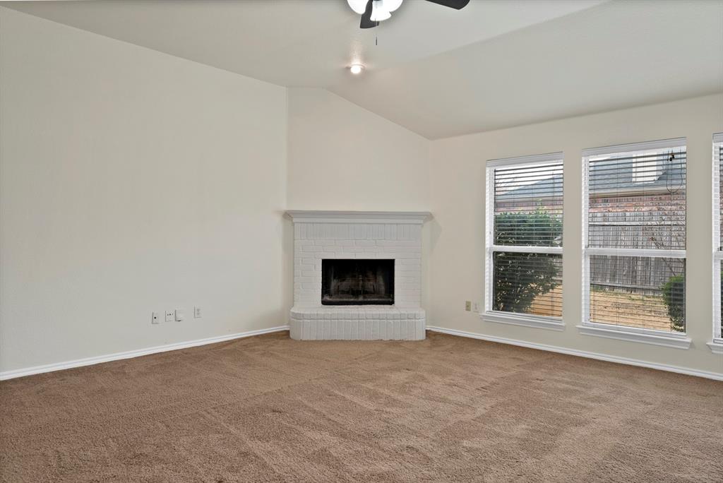 2832 Lone Ranger Trail Little Elm, TX 75068 - Photo 16 of 35 an empty room with a fireplace and windows