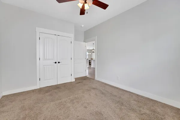 a spacious bedroom with a bed and a chandelier