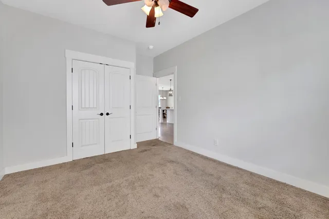 a spacious bedroom with a bed and a chandelier