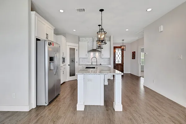 a view of a dining room and livingroom with furniture wooden floor a chandelier
