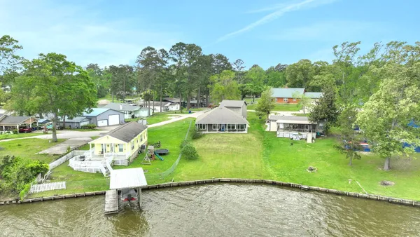 an aerial view of a house with a yard and lake view