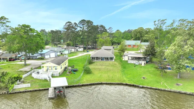 an aerial view of a house with a yard and lake view