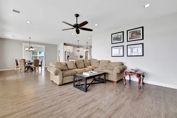 a living room with furniture flat screen tv and wooden floor