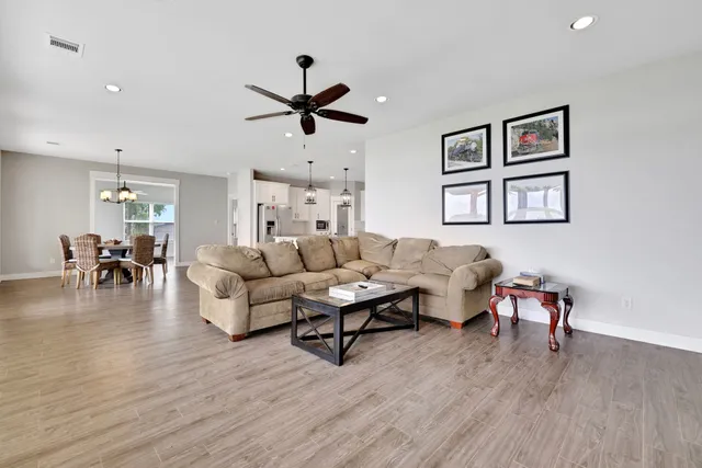 a living room with furniture flat screen tv and wooden floor