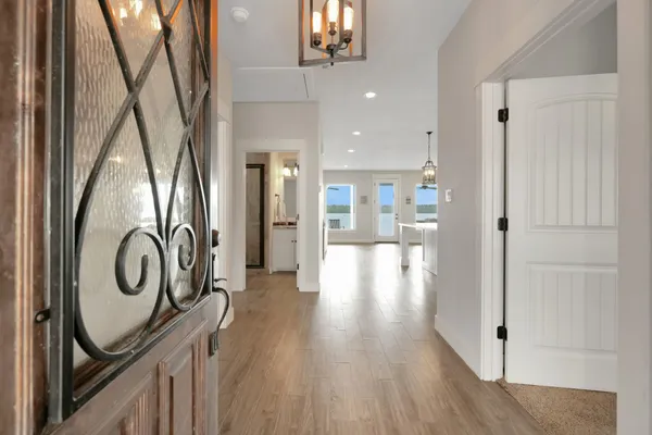 a view of a hallway with wooden floor and staircase