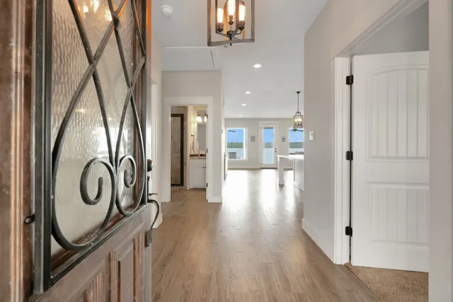 a view of a hallway with wooden floor and staircase