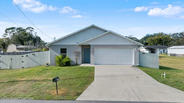 a front view of house with yard and garage
