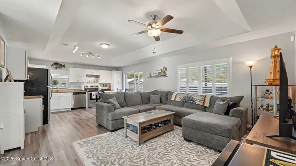 a living room with furniture kitchen view and a window
