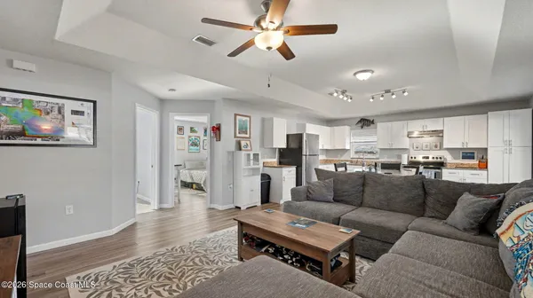 a living room with furniture kitchen view and a window