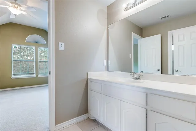 a bathroom with a granite countertop sink and mirror