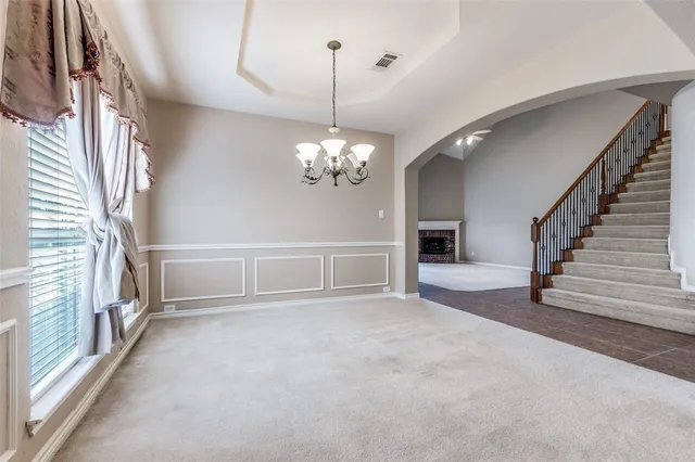 a view of a livingroom with a fireplace a chandelier and stairs