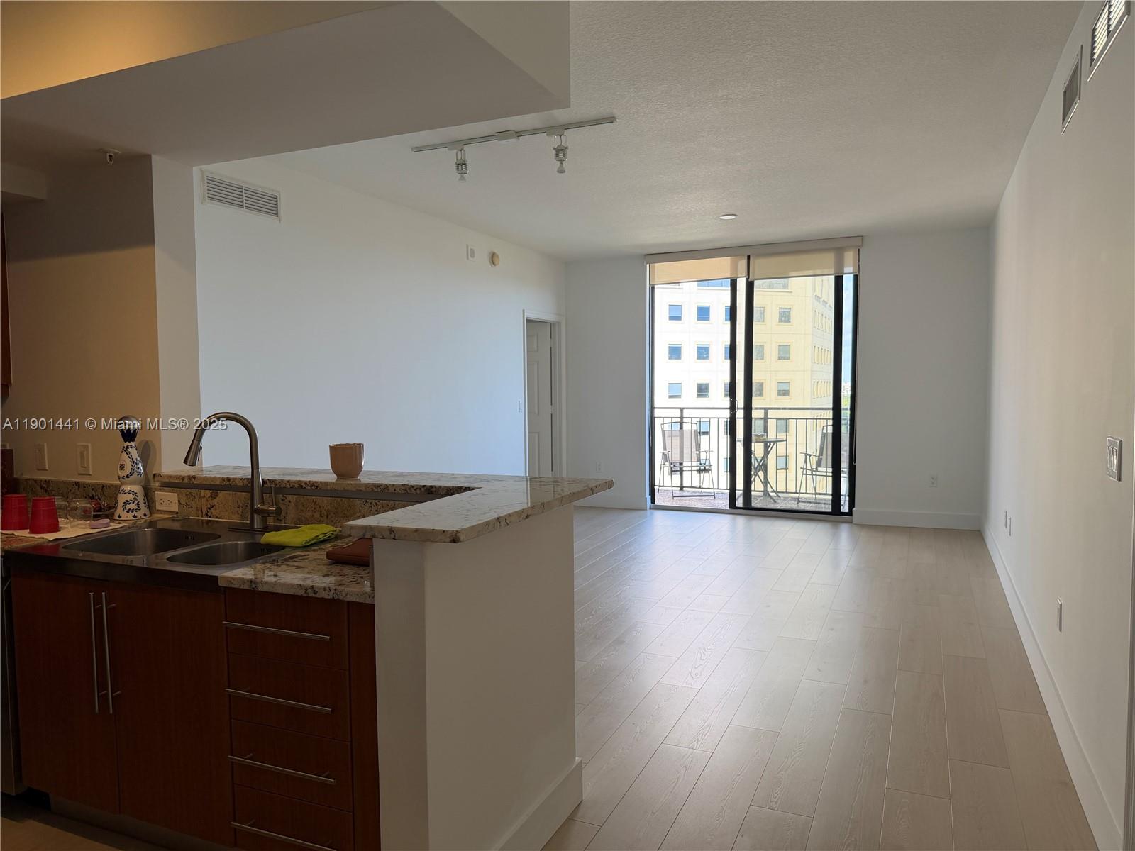 888 Douglas Road, Unit 917 Coral Gables, FL 33134 - Photo 11 of 31 a view of a sink and dishwasher with wooden floor