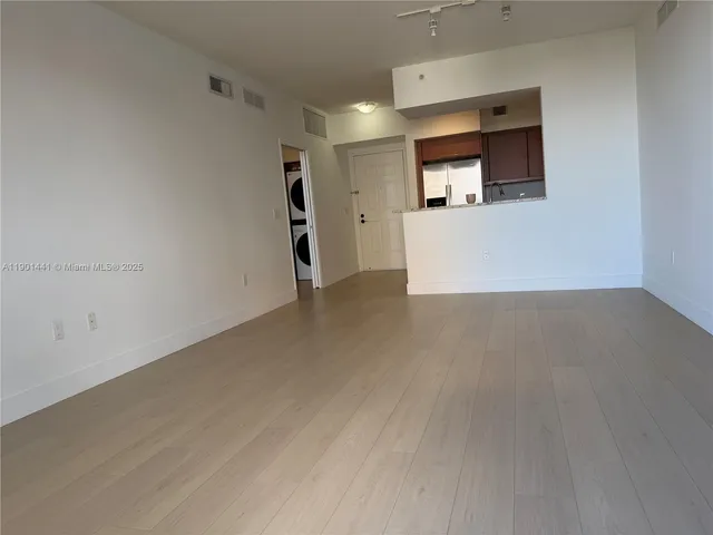 a view of a kitchen and an empty room with a kitchen
