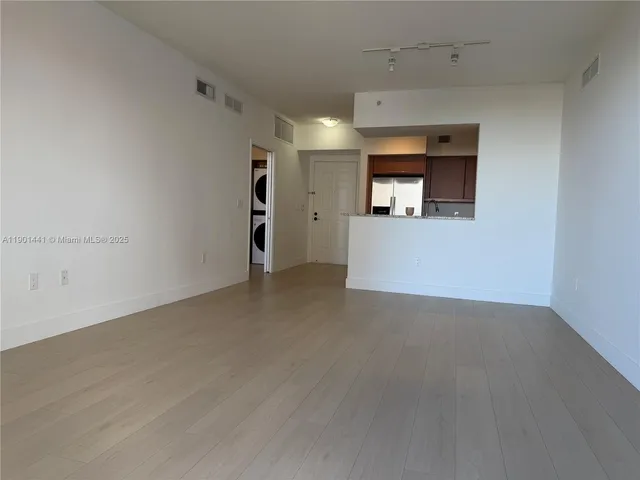 a view of a livingroom with wooden floor and a window