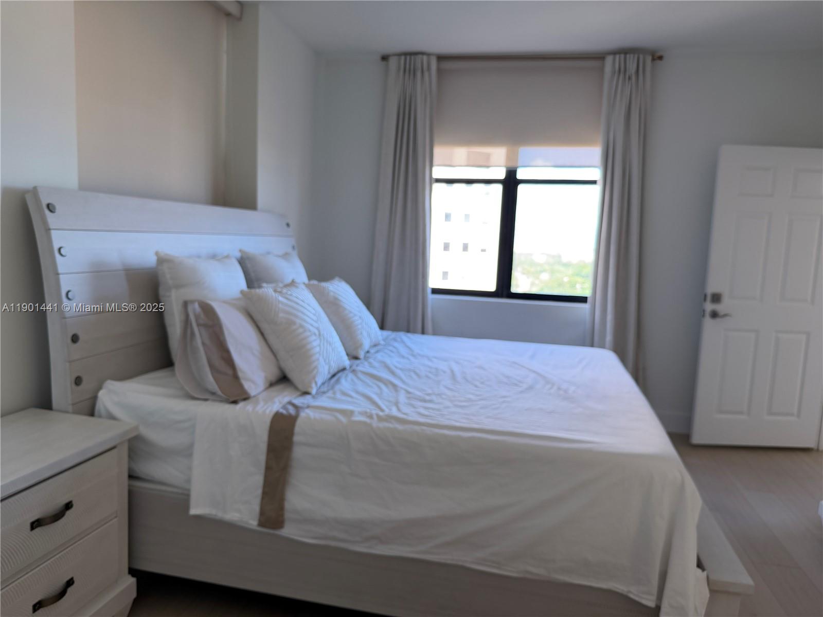 888 Douglas Road, Unit 917 Coral Gables, FL 33134 - Photo 18 of 31 a bedroom with a bed and window