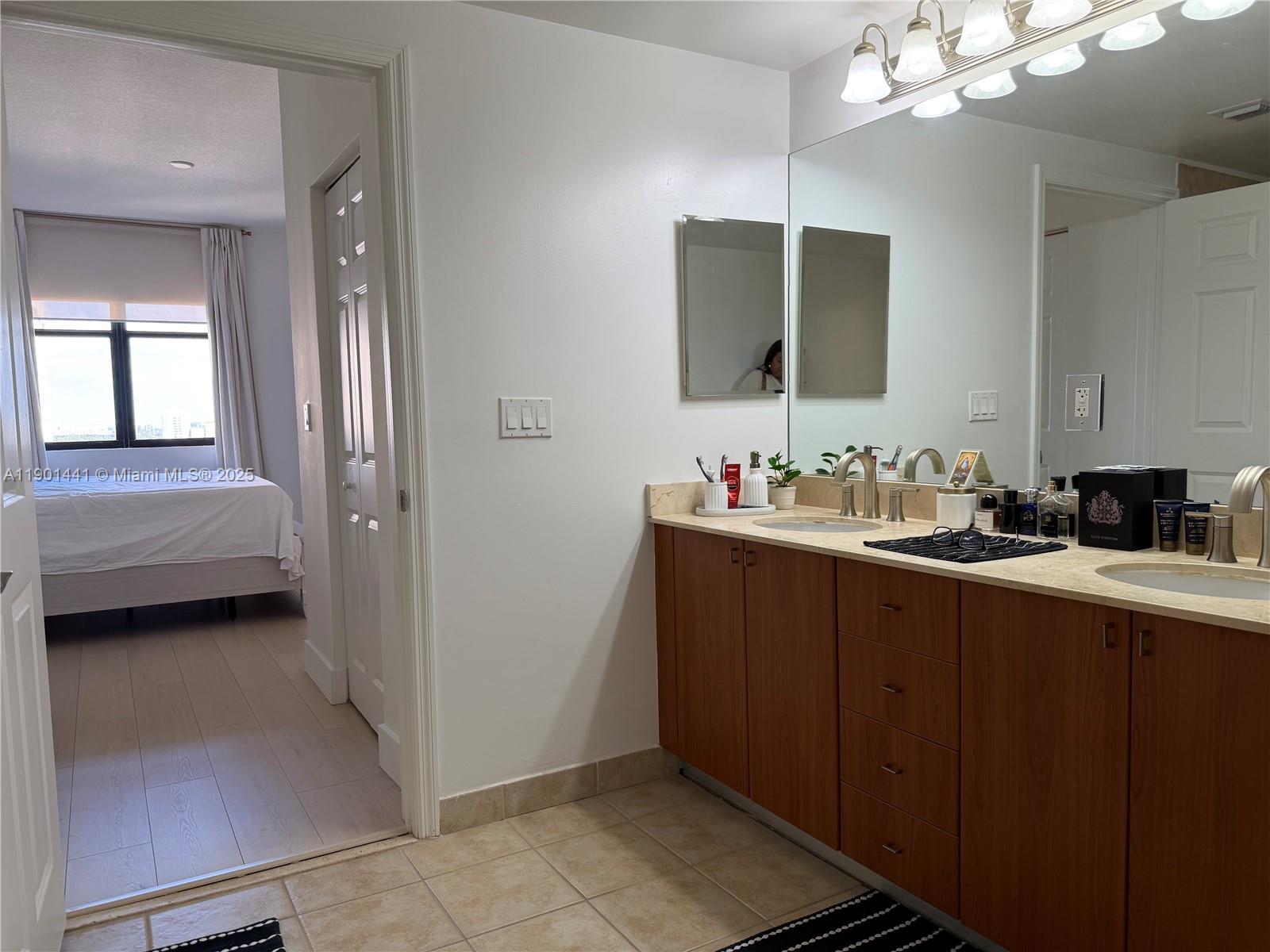 888 Douglas Road, Unit 917 Coral Gables, FL 33134 - Photo 19 of 31 a bathroom with a sink and a mirror