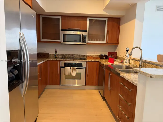 a kitchen with stainless steel appliances granite countertop a sink stove and refrigerator
