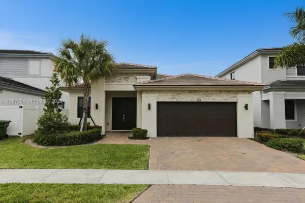 a front view of a house with a garden and garage