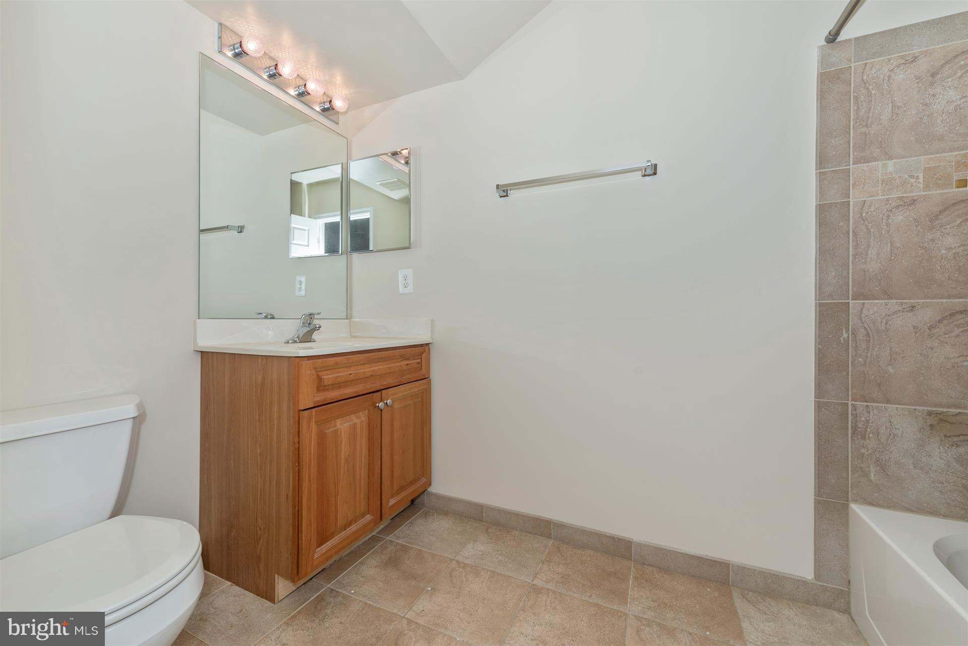 129 South Market Street Frederick, MD 21701 - Photo 13 of 37 a bathroom with a toilet a sink and mirror