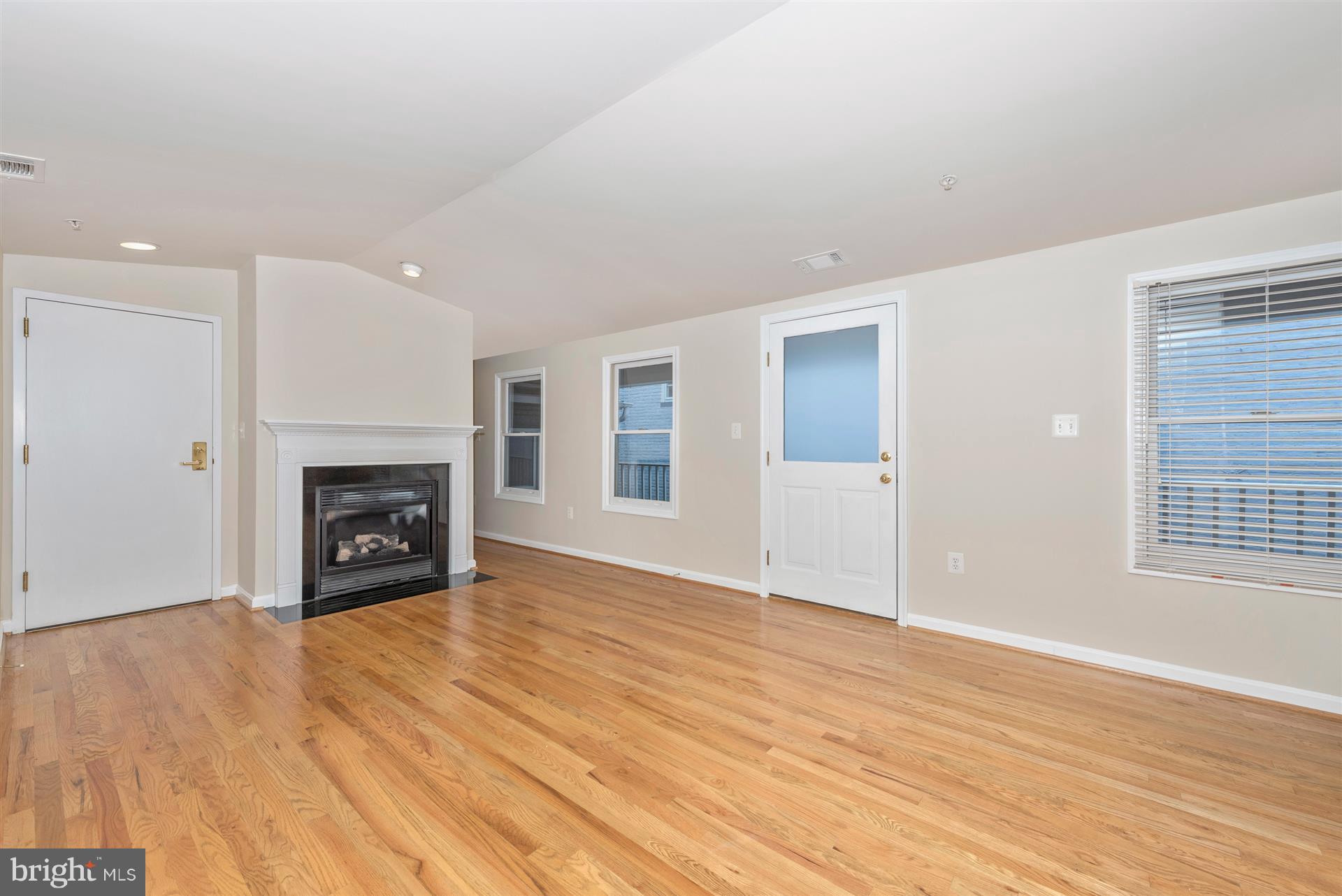 129 South Market Street Frederick, MD 21701 - Photo 20 of 37 an empty room with wooden floor fireplace and windows