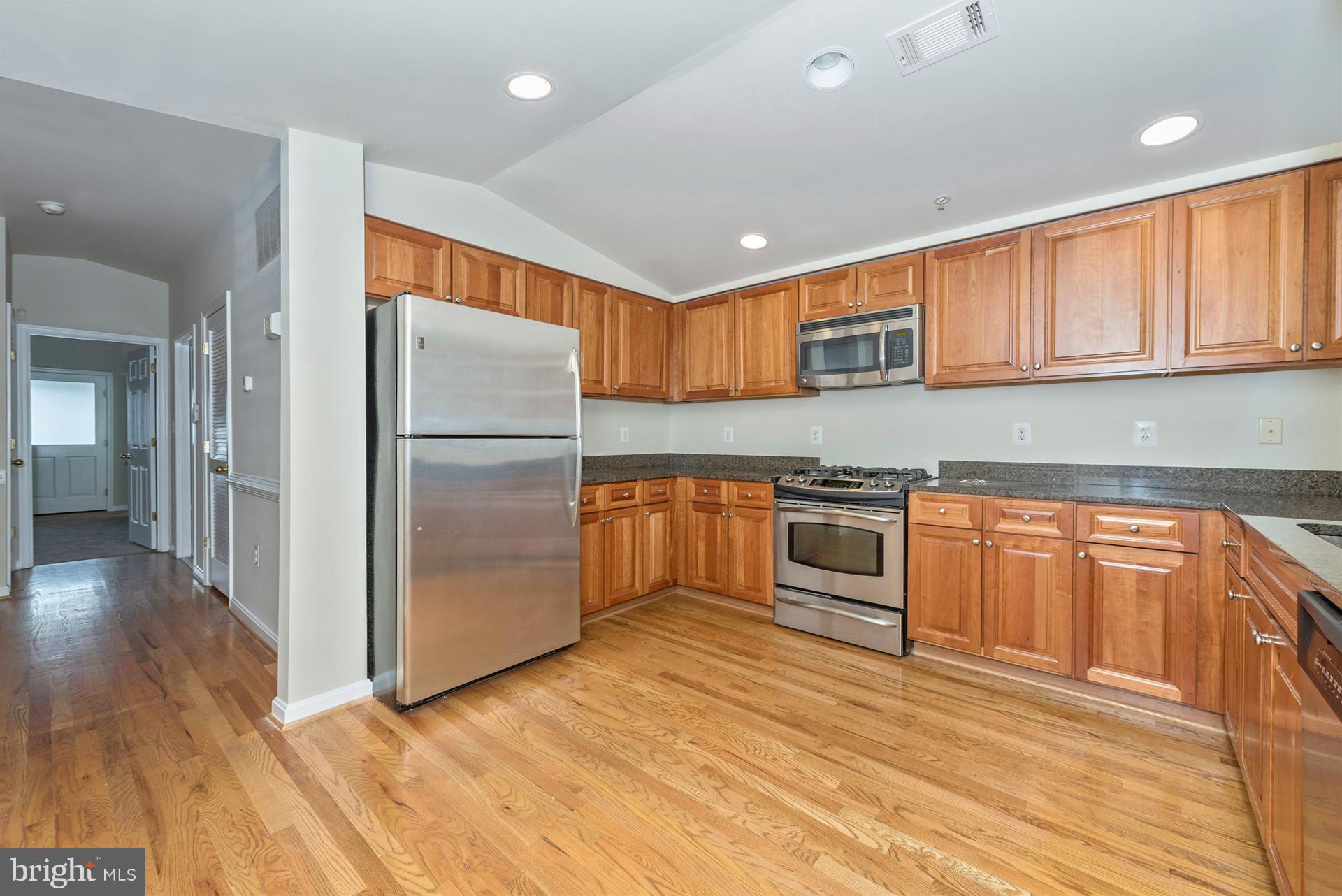 129 South Market Street Frederick, MD 21701 - Photo 4 of 37 a kitchen with granite countertop stainless steel appliances and wooden cabinets