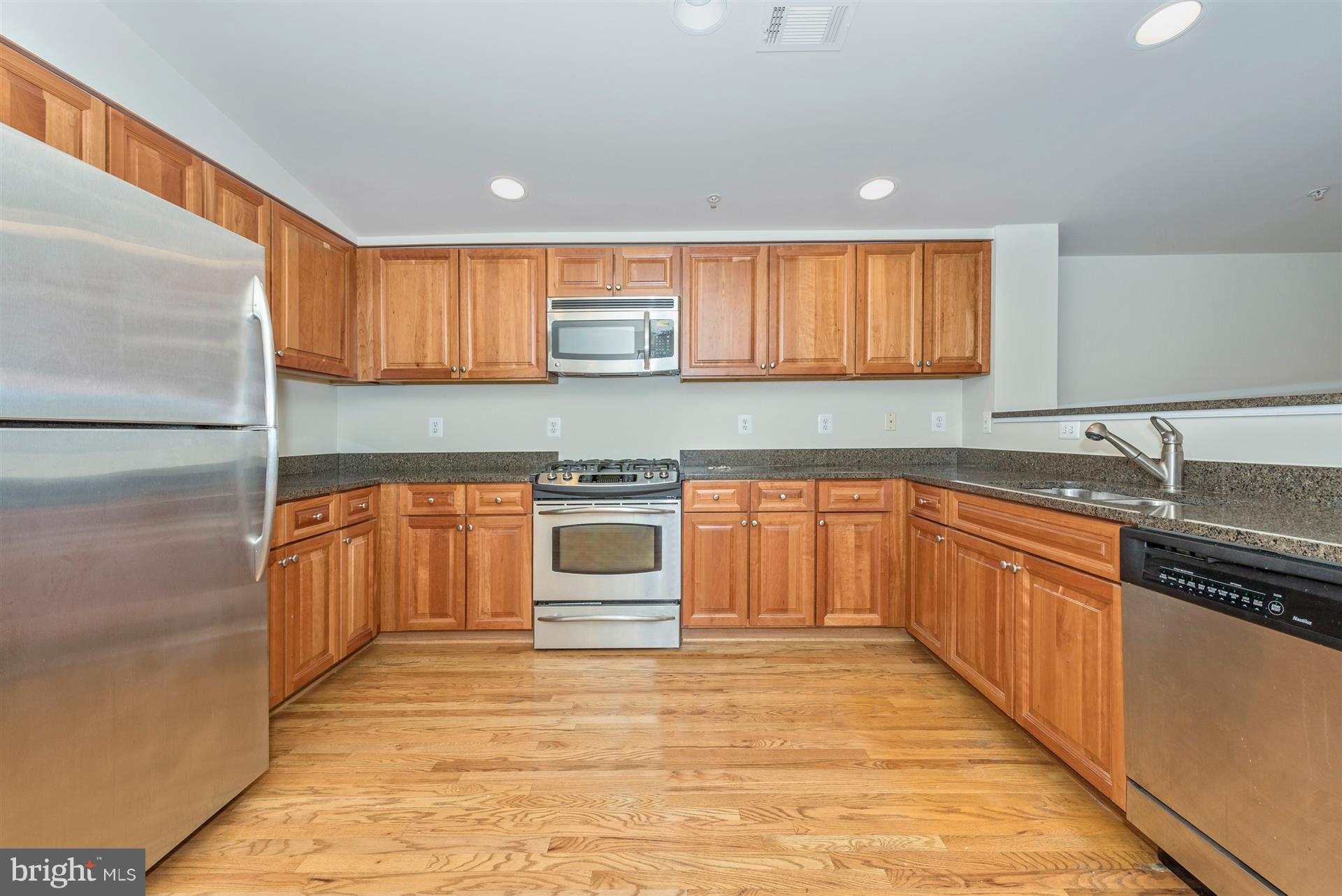 129 South Market Street Frederick, MD 21701 - Photo 5 of 37 a kitchen with granite countertop a sink cabinets stainless steel appliances and a window