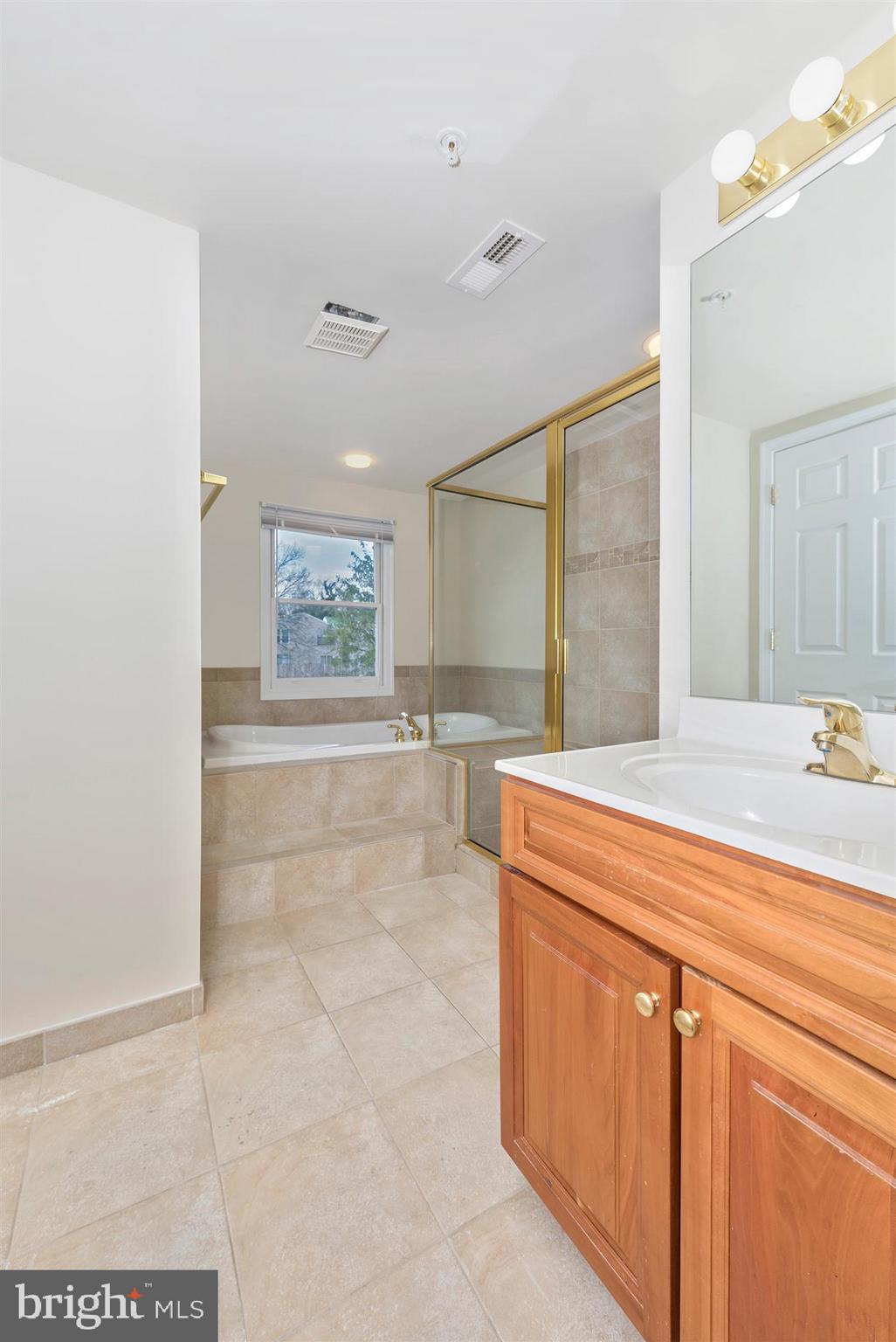 129 South Market Street Frederick, MD 21701 - Photo 10 of 37 a spacious bathroom with a granite countertop sink a mirror and a bathtub