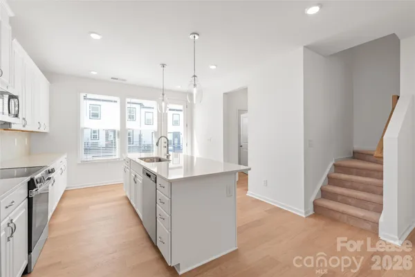 a kitchen with white cabinets and sink