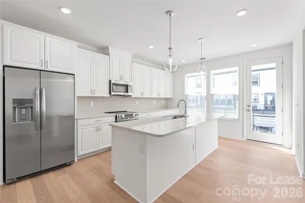 a open kitchen with stainless steel appliances granite countertop a refrigerator a sink and a stove