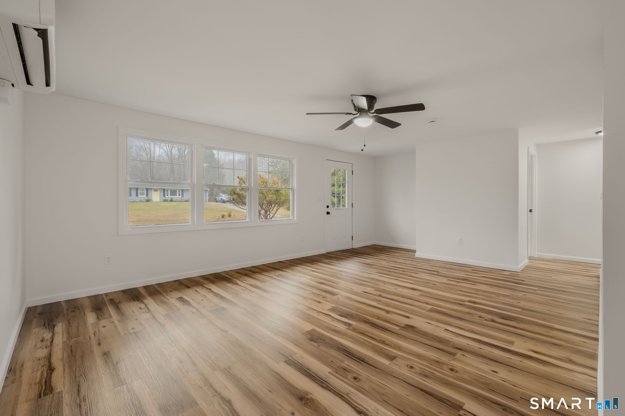 153 Meeting House Lane Ledyard, CT 06339 - Photo 10 of 39 an empty room with wooden floor chandelier fan and windows