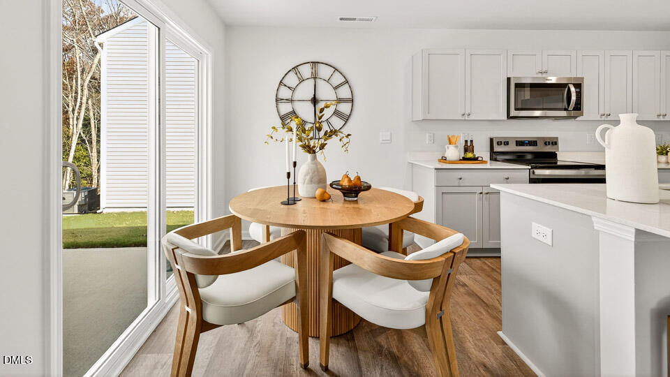 6037 Sodium Street Raleigh, NC 27610 - Photo 12 of 27 a kitchen with a dining table and chairs