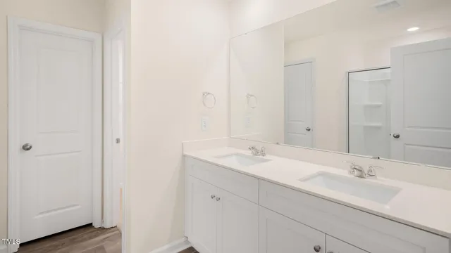 a bathroom with a double vanity sink and mirror