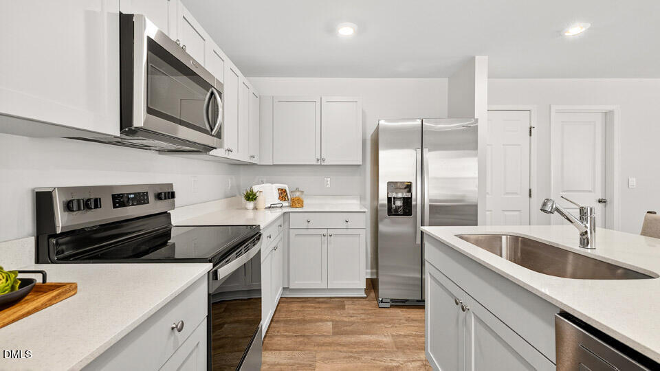 6037 Sodium Street Raleigh, NC 27610 - Photo 10 of 27 a kitchen with a sink cabinets and stainless steel appliances