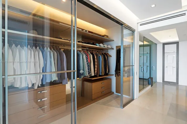 a view of walk in closet with clothes and shoes