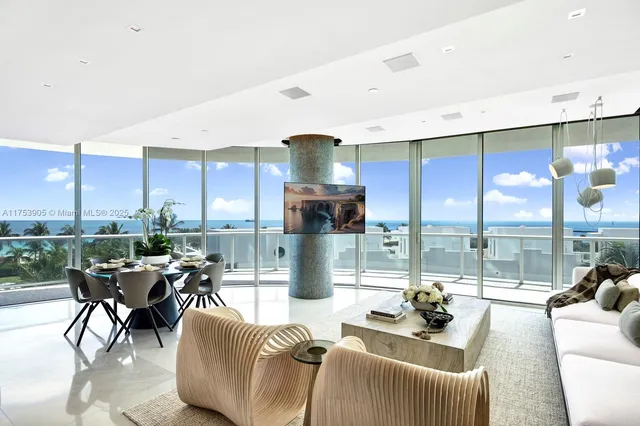 a dining room with furniture water view and a floor to ceiling window