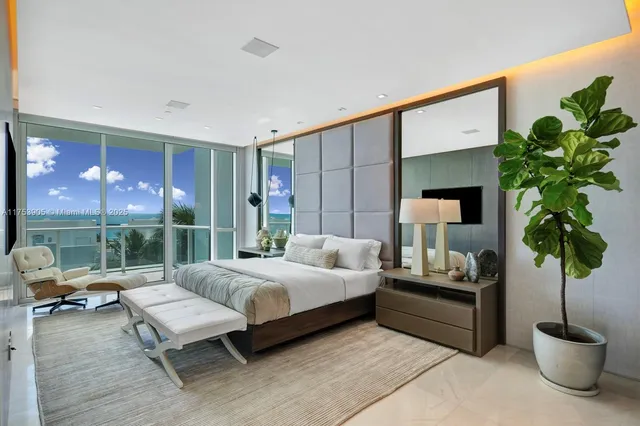 a bedroom with a large bed and a potted plant