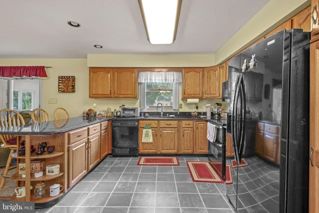 a kitchen with stainless steel appliances granite countertop a stove a sink dishwasher and a refrigerator