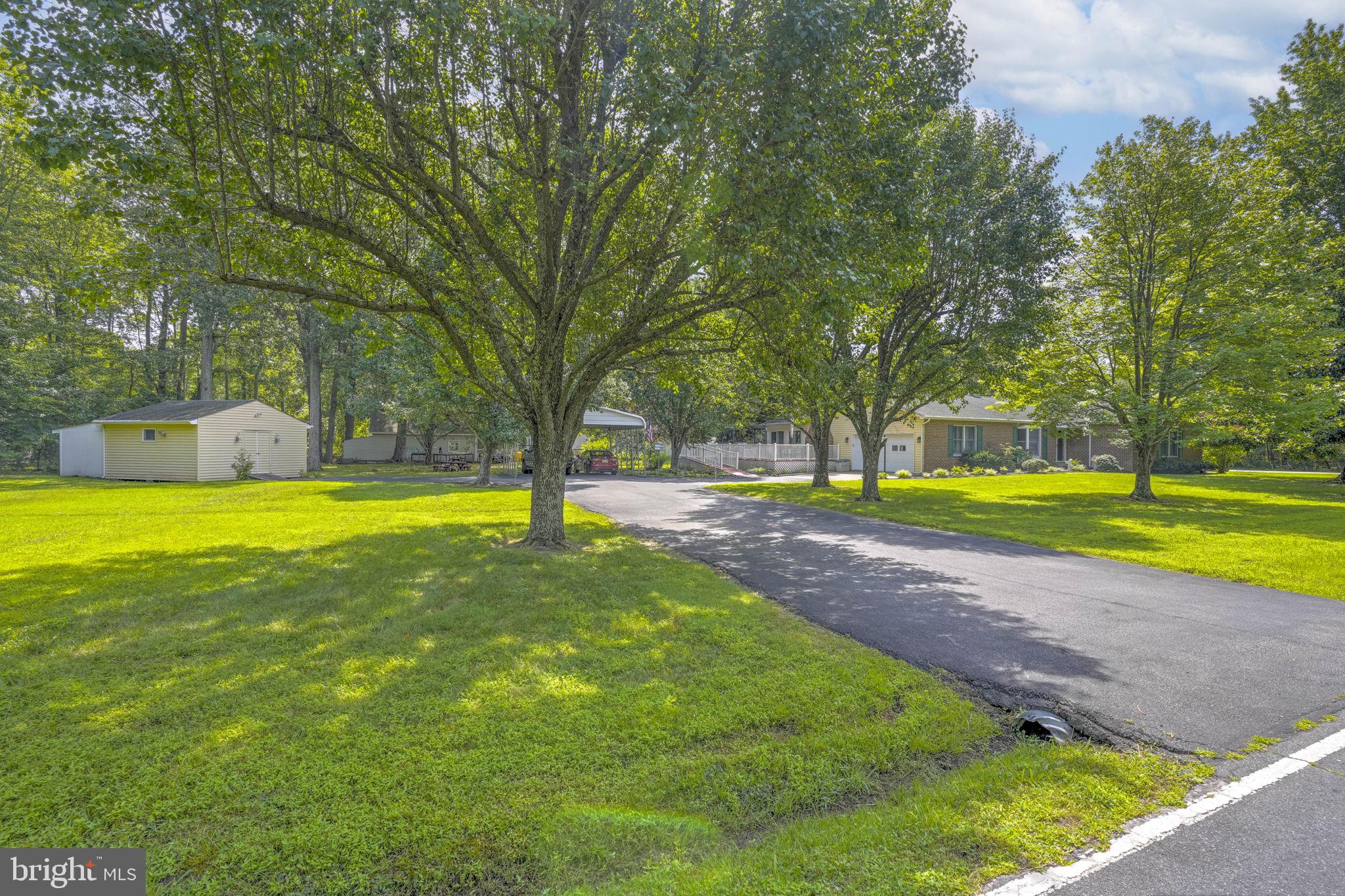 4949 Idlewilde Road Shady Side, MD 20764 - Photo 4 of 31 a view of a swimming pool with a garden and trees