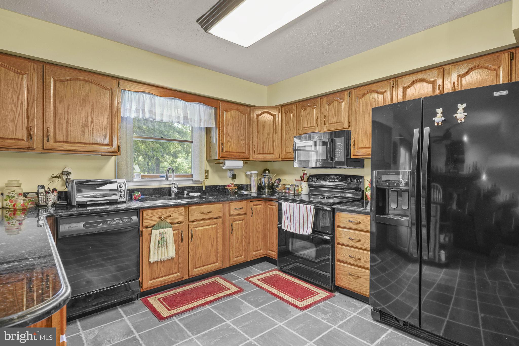 4949 Idlewilde Road Shady Side, MD 20764 - Photo 9 of 31 a kitchen with stainless steel appliances granite countertop a stove a sink dishwasher a refrigerator and cabinets with wooden floor