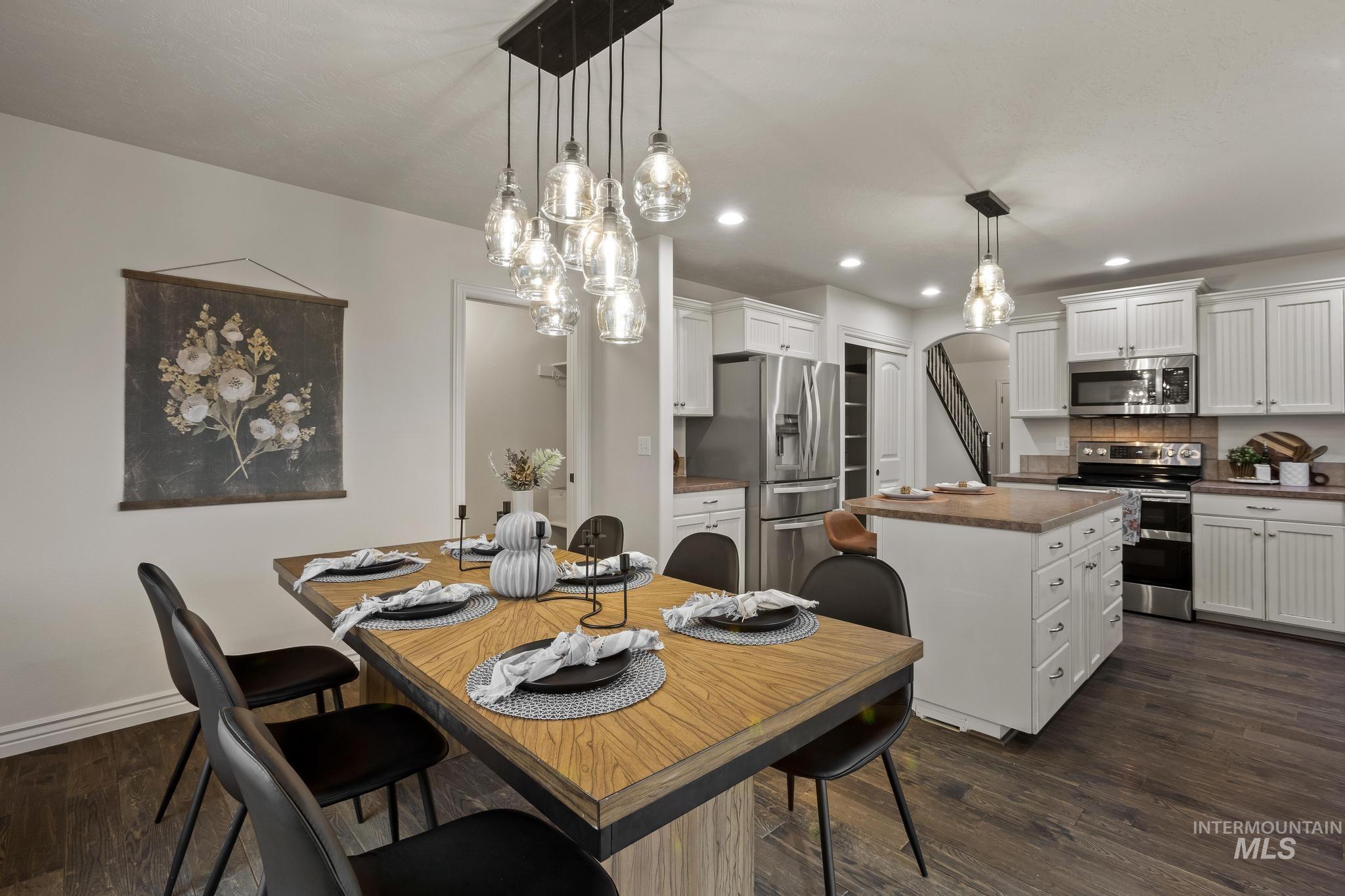 2185 Waterwheel Road Emmett, ID 83617 - Photo 11 of 49 Dining space with arched walkways, dark wood-style flooring, recessed lighting, and a chandelier